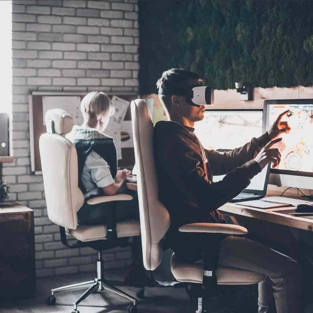 Homme assit face à son bureau qui utilise la VR pour ses projets