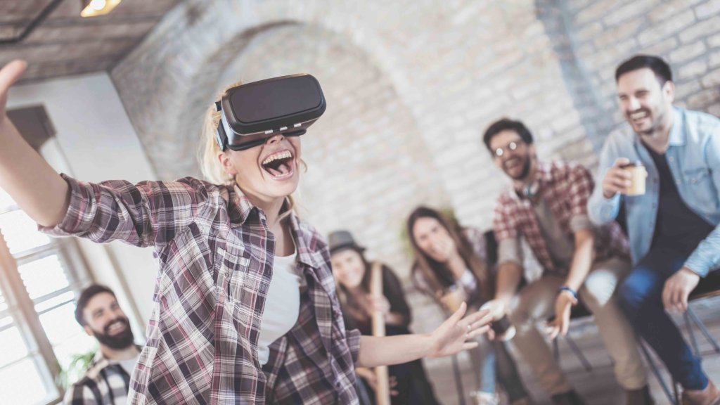 Femme avec un casque VR jouant devant ses amis