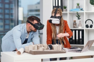 Architectes portant casques VR autour d'une maquette de bâtiment